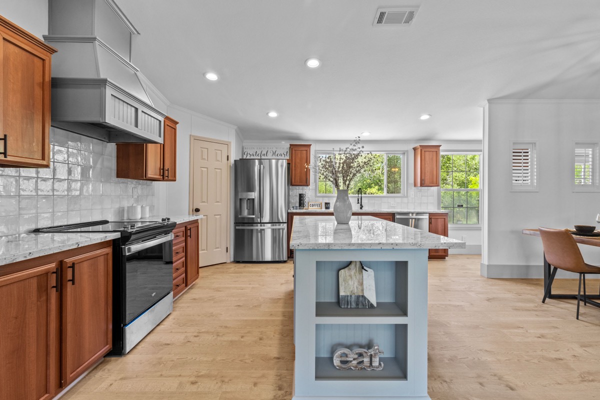 Open-concept kitchen with wood cabinets, center island, and natural light